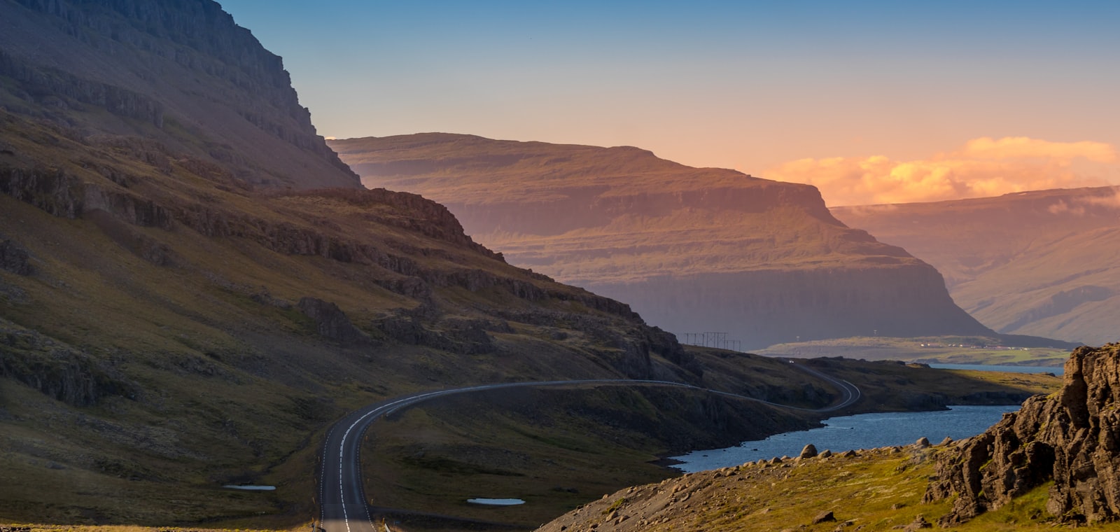 Kronkelende weg door een fjordlandschap in IJsland bij avondlicht